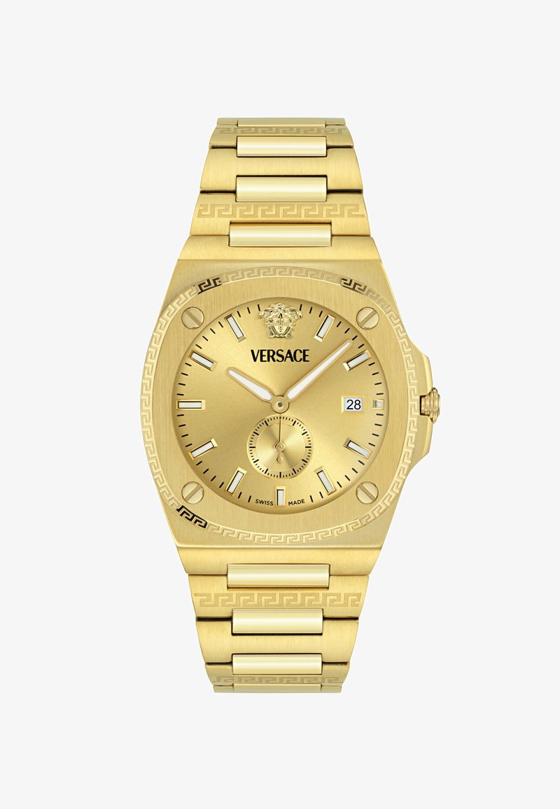 Złoty zegarek metalowy z okrągłą tarczą, białymi znacznikami godzinowymi, subtarcza oraz wzorzystym paskiem. Zauważalne logo umieszczone na górze tarczy.