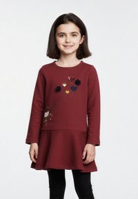 Abito lungo a maniche lunghe color bordeaux con gonna a campana, caratterizzato da un'illustrazione di un personaggio con accenti di palloncini colorati e dettagli floreali in rilievo.