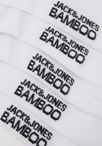 Weiße Bambussocken mit wiederholt eingesticktem schwarzen Text "JACK & JONES BAMBOO" über den Stoff, mit einer glatten Textur.