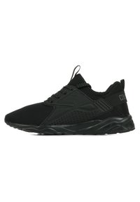 Chaussures de sport noires avec une tige en mesh, des lacets plats, un col rembourré et des accents texturés. La semelle est courbée pour un soutien et une flexibilité accrus.