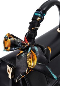 Borsa a mano in pelle nera con manico in seta annodata dai colori vivaci e design floreale. Accessori in metallo dorato accentuano la chiusura.