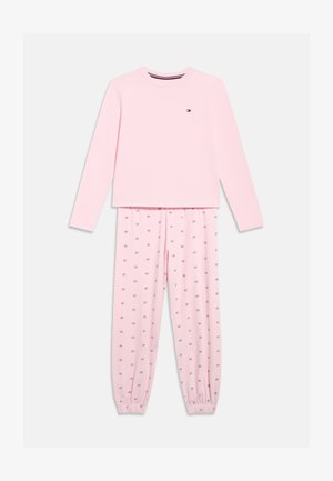 Világos rózsaszín hosszú ujjú felső és nadrág szett, a nadrág kis logó mintákkal díszített, a nadrágon rugalmas mandzsetták, a bal felső mellrészen diszkrét kis logó.