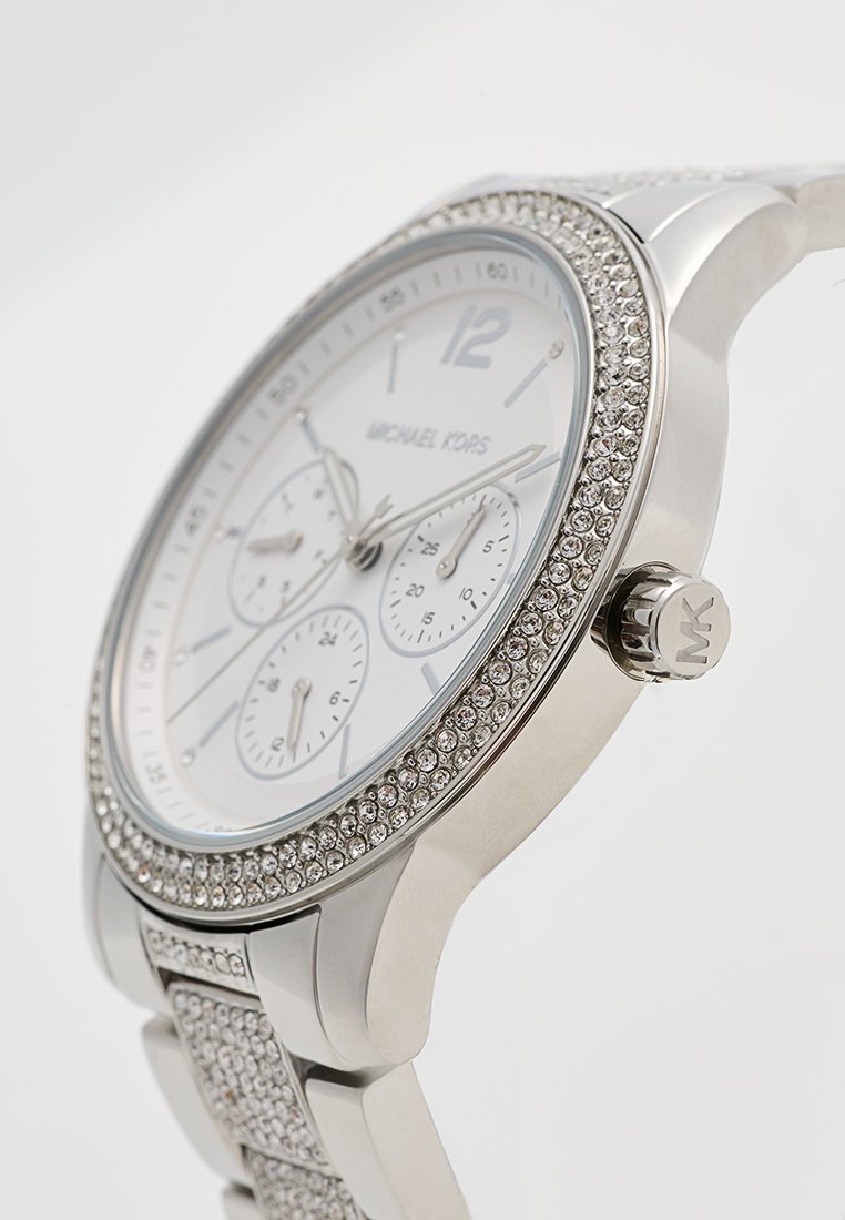Montre Michael Kors en argent avec un cadran blanc texturé, trois sous-cadrans chronographes, et une lunette et un bracelet incrustés de cristaux.