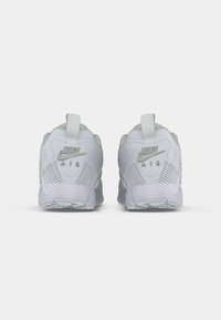 Ein Paar weiße Nike Air Sneakers von hinten betrachtet, mit dem Nike-Logo und einer strukturierten Sohle auf einem sauberen weißen Hintergrund.