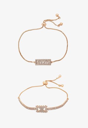 Kaksi säädettävää ruusukultaketjuista rannekorua, joissa suorakaiteenmuotoiset ja X-muotoiset timanttikoristeiset riipukset valkoisella taustalla.