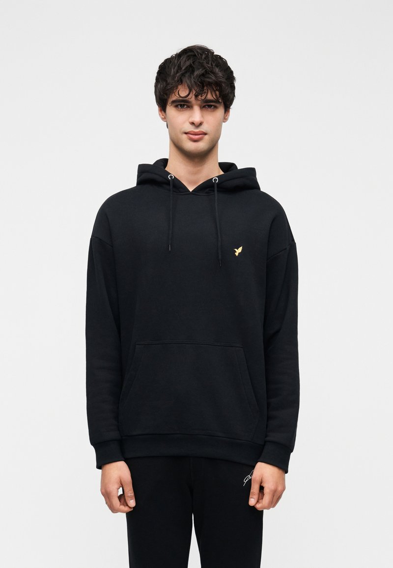 Μαύρο φούτερ με κουκούλα, που διαθέτει μπροστινή τσέπη, κορδόνια και μικρό χρυσό λογότυπο στο στήθος. Κατασκευασμένο από υφασμάτινη υφή.