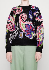 Pull noir avec des motifs cachemire et floraux colorés en rouge, vert, bleu et blanc. Manches longues avec poignets et ourlet côtelés.