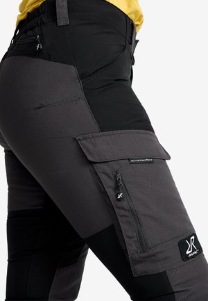 Cargo-byxor i en blandning av svarta och grå material, med en dragkedjeficka och logotyp-lapp, designade för hållbarhet och funktionalitet.