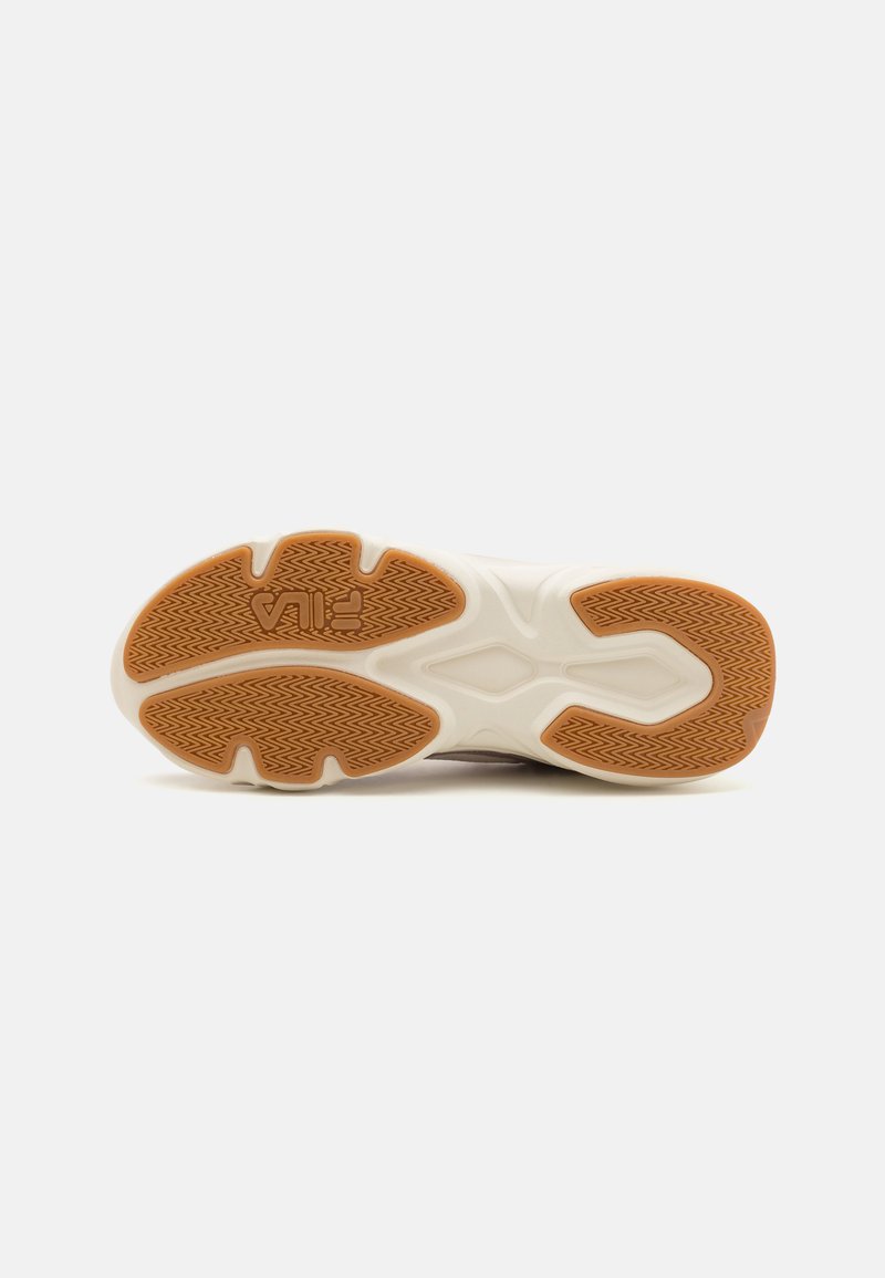 Sneaker met een gestructureerde rubberen zool. De buitenzool is bruin met een visgraatpatroon, voorzien van een witte tussenzool en een slank ontwerp.