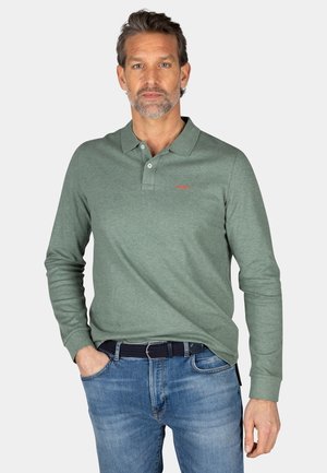 Langarm groene polo met een kraag, voorzien van een klein rood logo, gecombineerd met blauwe jeans en een zwarte riem. Soepele textuur.