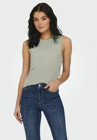 Lichtgrijze geribbelde tanktop met een hoge halslijn en mouwloos ontwerp, gecombineerd met donkerblauwe denim hoge taille jeans.