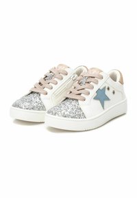 Zapatillas blancas con punteras plateadas brillantes, acentos de estrellas azules, cordones beige y marca rosa en la lengüeta; suelas de goma texturizadas.