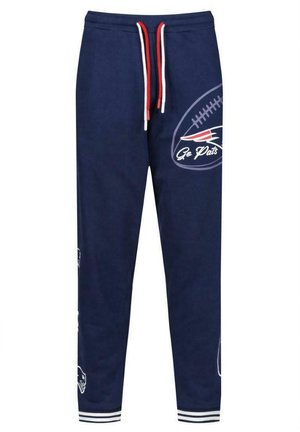 Pantaloni da tuta navy con lacci bianchi e rossi. Presentano loghi e grafiche del team. Vita elastica e orli a coste con dettagli a righe.