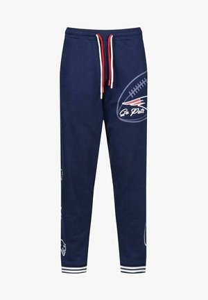 Pantaloni da tuta navy con lacci bianchi e rossi. Presentano loghi e grafiche del team. Vita elastica e orli a coste con dettagli a righe.