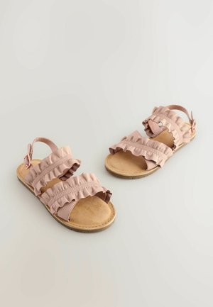 Rosa Sandalen mit drei Riemen und Rüschendetails, ausgestattet mit einem Schnallenverschluss, einer strukturierten braunen Sohle und weichen, flexiblen Materialien.