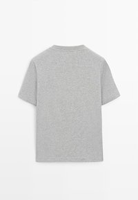 Szara koszulka z krótkim rękawem wykonana z miękkiej bawełny. Posiada okrągły dekolt i prosty dół, charakteryzuje się gładką fakturą i brakiem widocznych wzorów.