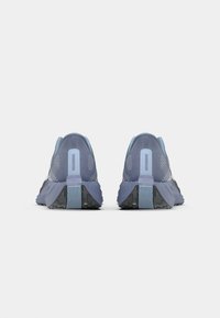 Blue athletic shoes with a mesh upper, textured heel, and contrasting black rubber outsole. Features a minimalistic design and reflective accents.