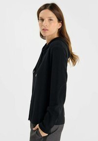 Zwarte hoodie cardigan met lange mouwen en een relaxed fit, met een gladde textuur en metallic trekkoorden.