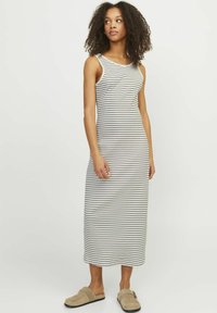 Abito maxi a righe in tessuto leggero, con design senza maniche e scollatura rotonda. Colori: bianco con righe scure.