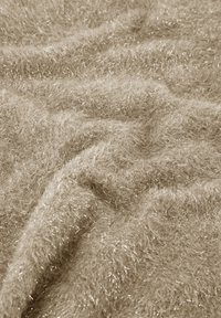 Zachte, gestructureerde stof in beige met dunne, glanzende draden die door de stof zijn geweven, wat een fluffy, gelaagd uiterlijk creëert.
