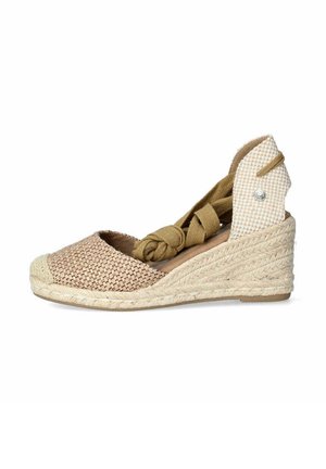 Alpargatas de cuña con un upper de tejido de color marrón claro, tela de cuadro crema en el talón y una plataforma de yute trenzado. Detalles de atado en el tobillo.