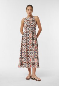 Maxikleid mit einem bunten geometrischen Muster in Rot-, Blau- und Cremetönen. Hergestellt aus leichtem Stoff, mit einem taillierten Oberteil und einem fließenden Rock gestaltet.