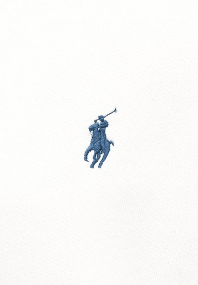 Μπλε κέντημα ενός παίκτη πόλο που ιππεύει άλογο και κουνάει ένα σφυρί πάνω σε λευκό υφασμάτινο φόντο με υφή.