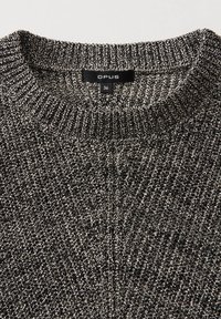 Pull en maille chinée noir et blanc avec col rond côtelé et une étiquette noire taille 36 portant la mention « OPUS » cousue à l’intérieur du col.