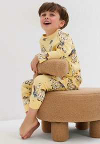 Pigiama giallo con stampa di animali giocosa, composto da maniche lunghe e pantaloni. Materiale in cotone morbido, colletto a girocollo e polsini aderenti.