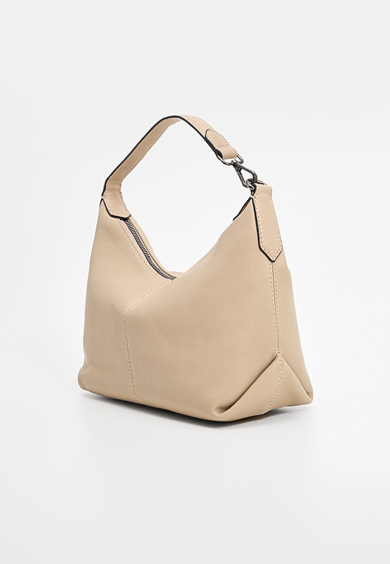 Sac à main en cuir beige à la forme décontractée, doté d'une courte hanses et de détails de couture noir contrastants. Fermeture zippée.