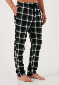 Zwart en groen geruite flanel broek met een elastische tailleband, trekkoord en zijzakken. Zachte textuur en recht-pijpen ontwerp.