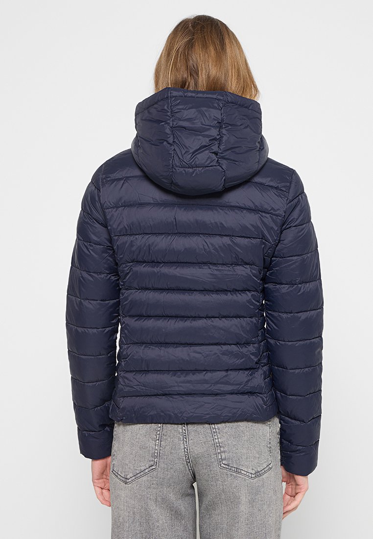 Giacca imbottita con cappuccio di colore blu navy, con cuciture orizzontali, texture lucida e design aderente, vista da dietro.