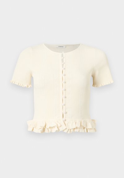 Μπεζ ριμπ πλεκτή ζακέτα με κοντά μανίκια, διακοσμημένα με περλίτσες κουμπιά μπροστά και βολάν στα τελειώματα του ρεβέρ και των μανικιών.