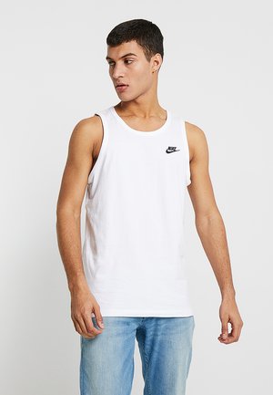 Hvid bomulds tanktop med rund hals og et lille sort Nike-logo på brystet. Stylet med lysblå denim jeans.