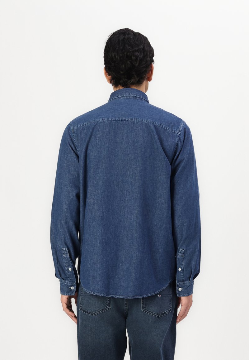 Dunkelblaue Jeanshemd mit Knopfkragen, langen Ärmeln und abgerundetem Saum. Verfügt über doppelte Knopfmanschetten und eine glatte Textur.