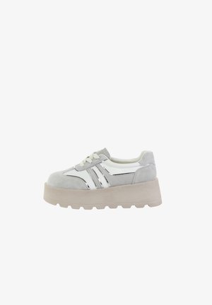 Gruba platforma sneakersów w kolorze białym i jasnoszarym z zamszowymi akcentami, sznurowane z przodu i z wyrazistą beżową podeszwą.