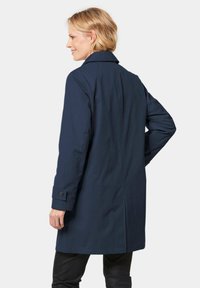 Navyblauer langer Mantel aus glattem Material, mit einem gekerbten Kragen und geknöpften Ärmeln. Ein elegantes, minimalistisches Design mit geradem Schnitt.