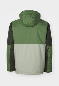 Veste à capuche verte et grise avec un design en color-block. Texture lisse, avec des manches vert foncé et un motif à rayures verticales sur le haut.