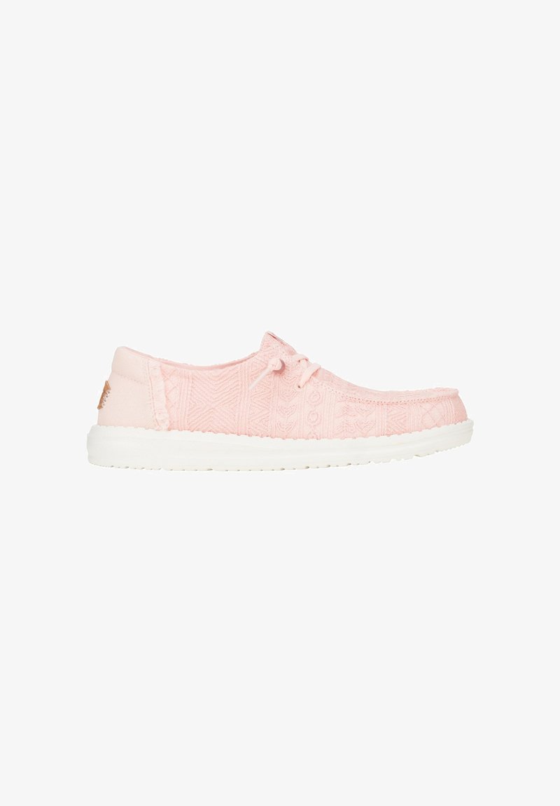Lichtroze veterschoenen met een gestructureerde stof en decoratieve patronen. Witte rubberen zool met subtiele branding op de hak.