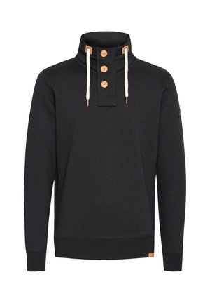 Schwarzer Pullover mit hohem Kragen, ausgestattet mit drei Holzknöpfen, cremefarbenen Kordeln und strukturiertem Rippstoff. Kleines Markenetikett am Saum.