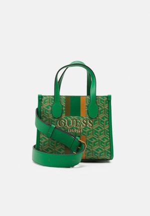 Sac à main vert Guess avec motif géométrique, deux poignées supérieures, large bandoulière amovible et logo doré sur le devant avec des rayures verticales.