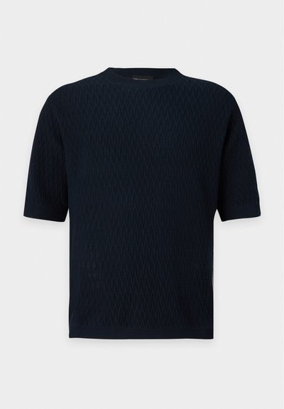 Haut tricoté bleu marine foncé à manches courtes avec motif zigzag texturé et encolure ronde, poignets et ourlet côtelés.
