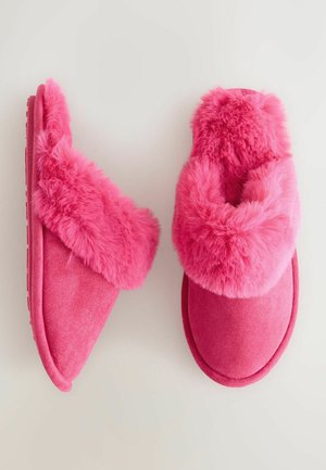 Pink slippers featuring a faux fur upper and a flat, textured sole. The design includes a thick, fluffy band across the instep.