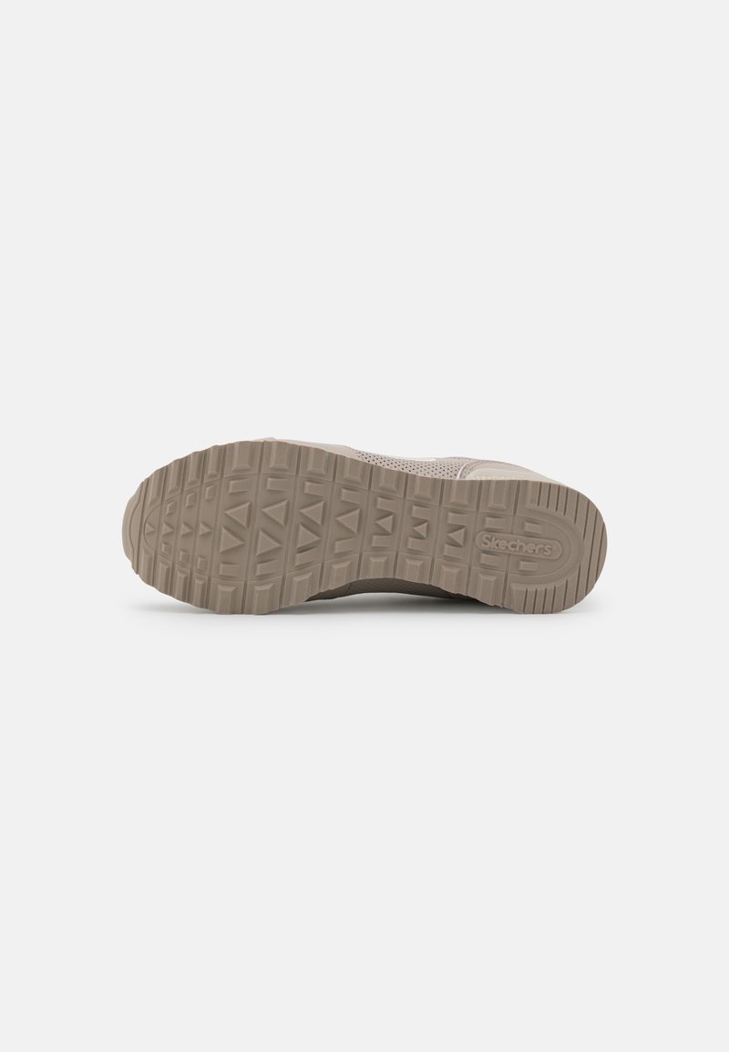 Suela de zapato Skechers beige con textura de suela y logo de la marca visible sobre un fondo blanco liso.