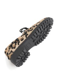 Schuh mit Leopardenmuster, texturiertem, beigem Obermaterial, schwarzen Schnürsenkeln und einer robusten, schwarzen Gummisohle mit tiefen Profilmustern für besseren Halt.