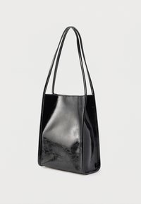 Sac cabas en cuir verni noir avec des anses fines et allongées, forme rectangulaire, texture lisse et design minimaliste.