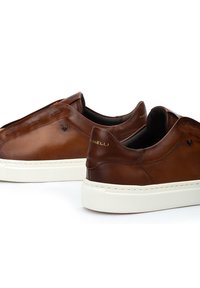 Zapatillas de cuero marrón con una textura suave, suela de goma blanca, acentos cosidos y un sutil logotipo en los lados.