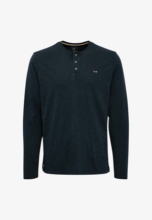 Pikad varrukad, tumesinine särk, mis on valmistatud pehmest kangast. Omab ümmargust kaelust, kolme nupuga lahtist ja rinna peal väikest logo detaili.