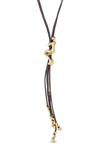 Pendentif figurine en ton or sur trois cordons en cuir noir, présentant des courbes lisses et une forme abstraite, avec de petits accents décoratifs.