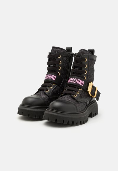Stivaletti neri con una finitura scintillante, accessori dorati e una fascia con logo rosa; presentano una suola con battistrada spesso e un sistema di allacciatura.